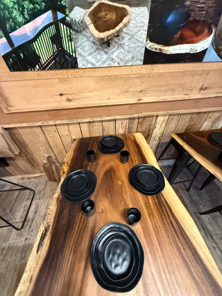 Wooden table with black circular objects on a wooden floor.